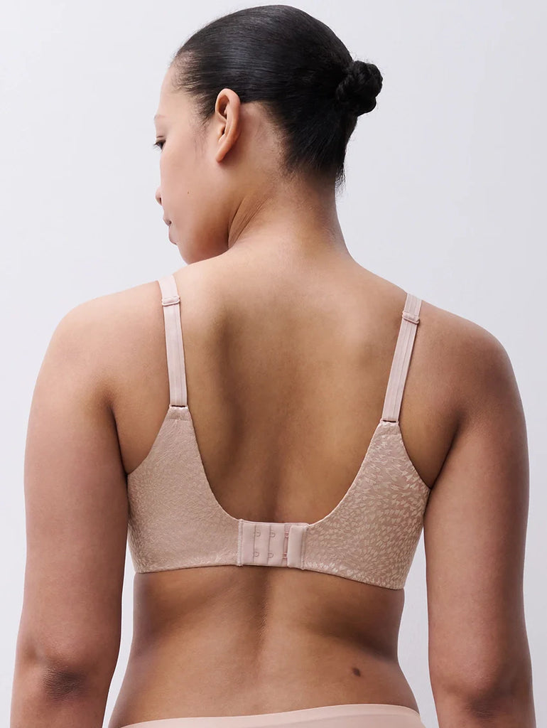 Woman wearing a soft pink bra against a plain background Chantelle Magique Seamless Bra